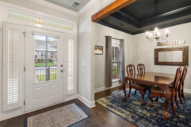 foyer with crown molding, dark wood-type flooring, and a chandelier