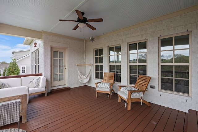 wooden deck with outdoor lounge area and ceiling fan