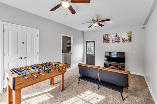 playroom featuring ceiling fan, washer and clothes dryer, and carpet