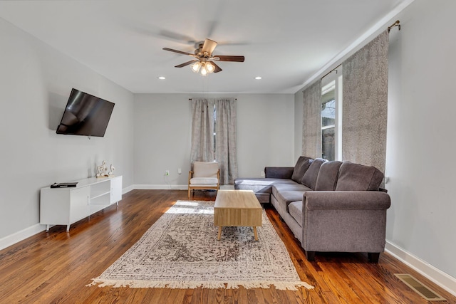 living room with ceiling fan and dark hardwood / wood-style flooring