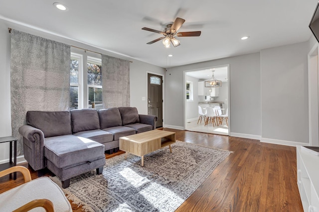 living room with dark hardwood / wood-style flooring and ceiling fan