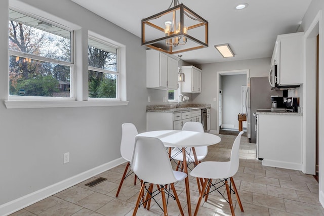 dining space with sink and an inviting chandelier