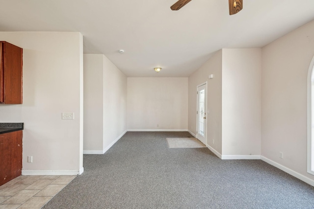 empty room featuring ceiling fan and light colored carpet