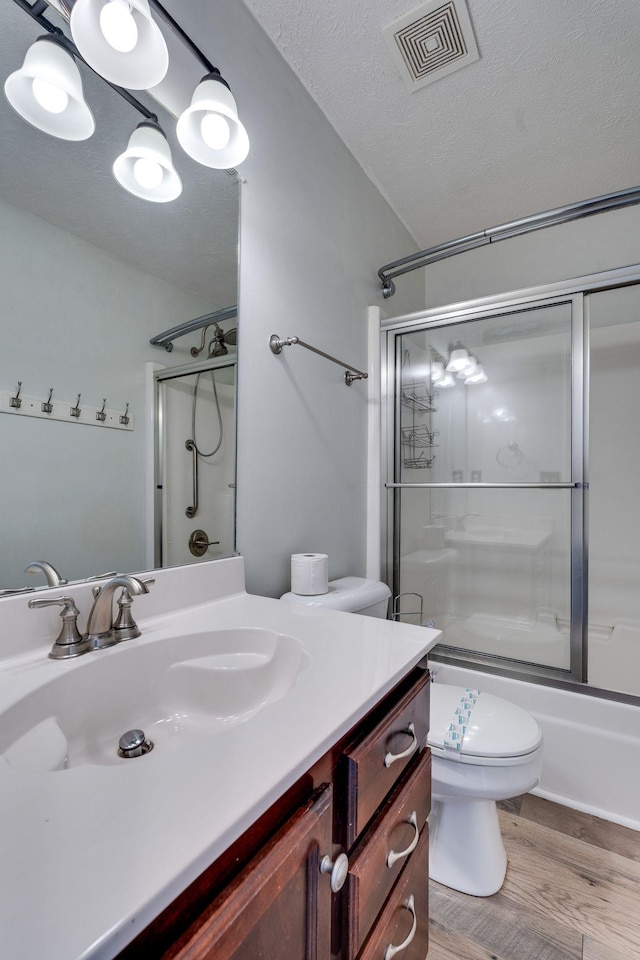 full bathroom with enclosed tub / shower combo, lofted ceiling, toilet, vanity, and hardwood / wood-style flooring