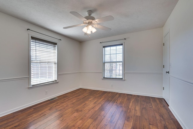 empty room featuring a textured ceiling, ceiling fan, and dark wood-type flooring