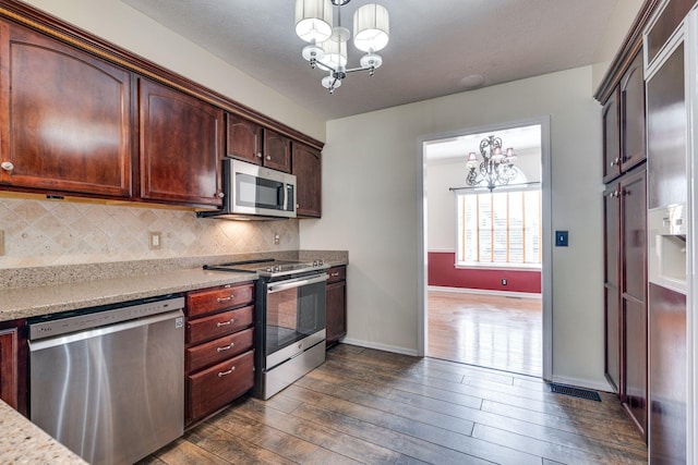 kitchen featuring decorative light fixtures, decorative backsplash, a notable chandelier, dark hardwood / wood-style flooring, and stainless steel appliances