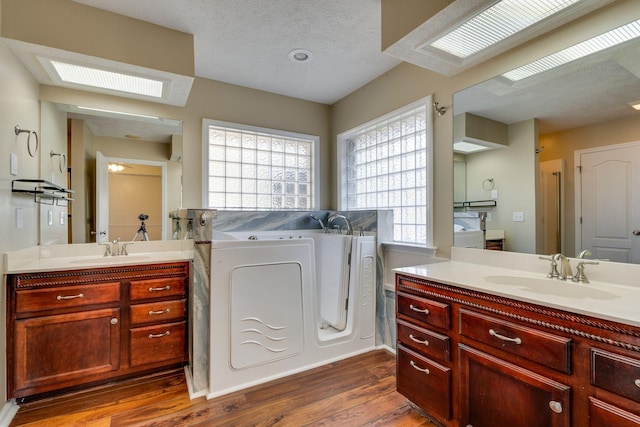 bathroom featuring hardwood / wood-style flooring, vanity, and a textured ceiling