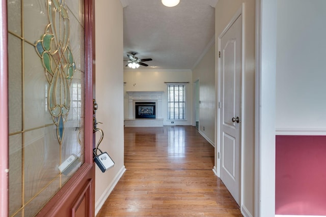 corridor with ornamental molding and light wood-type flooring