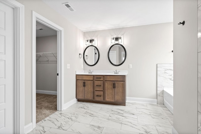 bathroom with a sink, visible vents, baseboards, marble finish floor, and double vanity