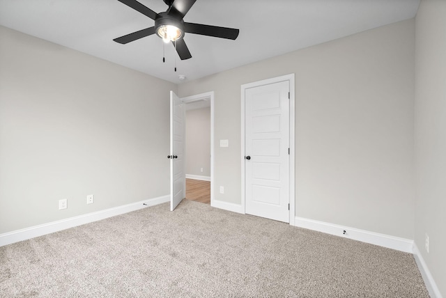 unfurnished bedroom with ceiling fan, carpet floors, and baseboards