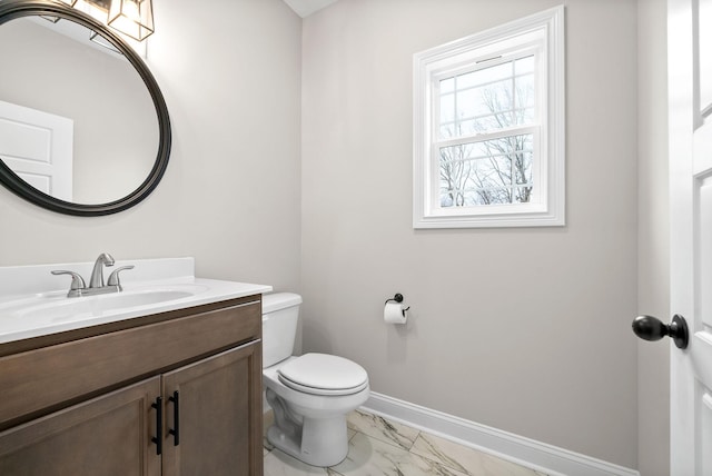 bathroom featuring marble finish floor, vanity, toilet, and baseboards