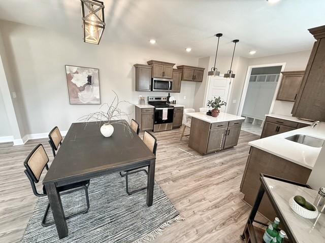 interior space with baseboards, light wood finished floors, and recessed lighting