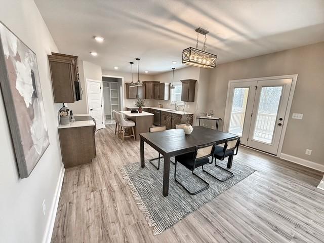 dining area with light wood finished floors, plenty of natural light, recessed lighting, and baseboards