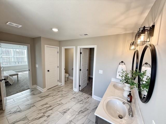 bathroom featuring marble finish floor, baseboards, visible vents, and a sink