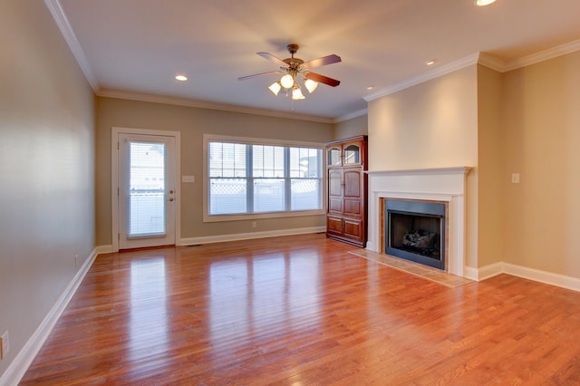 unfurnished living room with hardwood / wood-style flooring, ceiling fan, and crown molding