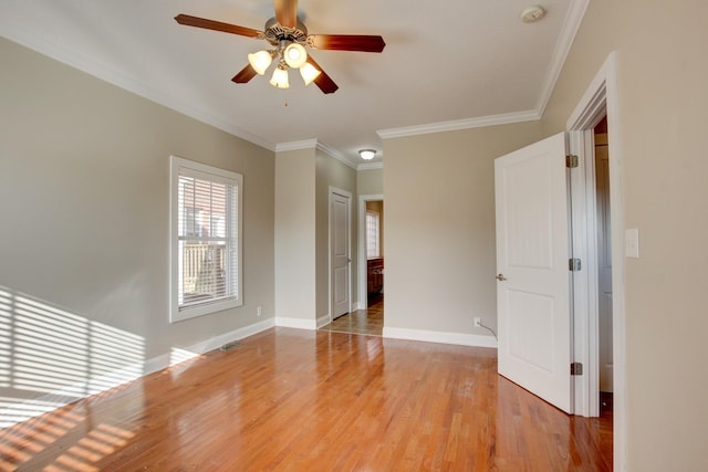 spare room with ceiling fan, light wood-type flooring, and ornamental molding