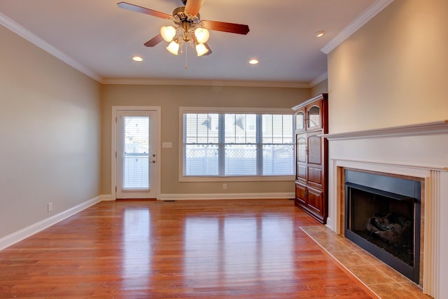 unfurnished living room with a fireplace, light wood-type flooring, ceiling fan, and crown molding