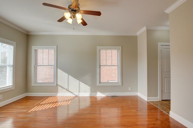 empty room with a healthy amount of sunlight, light hardwood / wood-style floors, ceiling fan, and ornamental molding