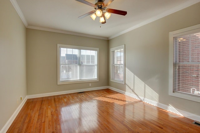 spare room featuring a healthy amount of sunlight, light hardwood / wood-style floors, and crown molding