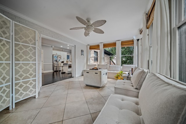 living room featuring ceiling fan, ornamental molding, and light tile patterned flooring