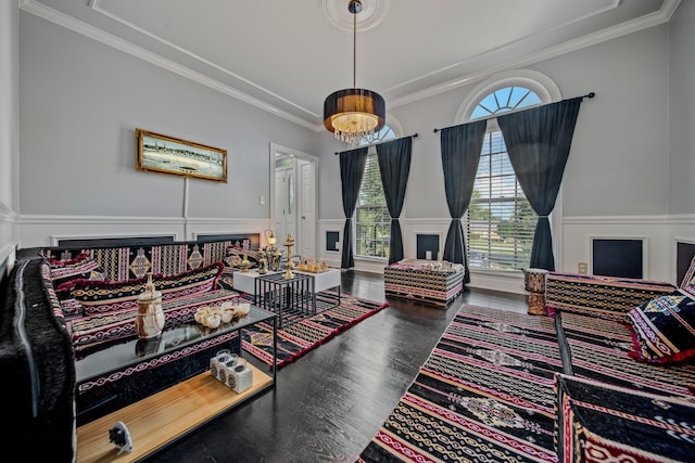 living room featuring dark hardwood / wood-style floors, an inviting chandelier, and crown molding