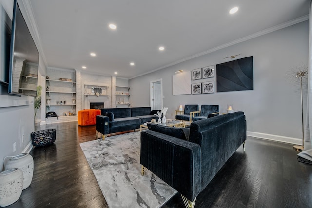 living room with a brick fireplace, dark wood-type flooring, built in features, and ornamental molding