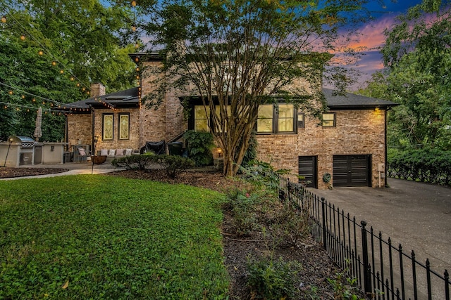 view of front of house with a garage and a yard