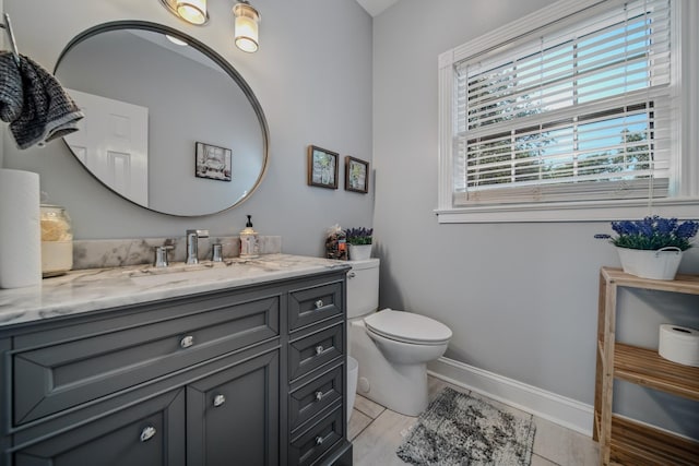 bathroom with tile patterned flooring, vanity, and toilet