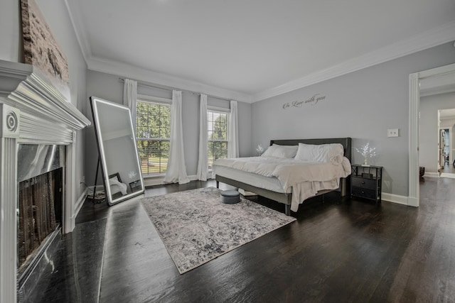 bedroom with crown molding, a high end fireplace, and dark wood-type flooring