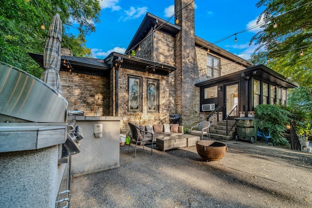 view of front of house featuring outdoor lounge area, cooling unit, and a patio