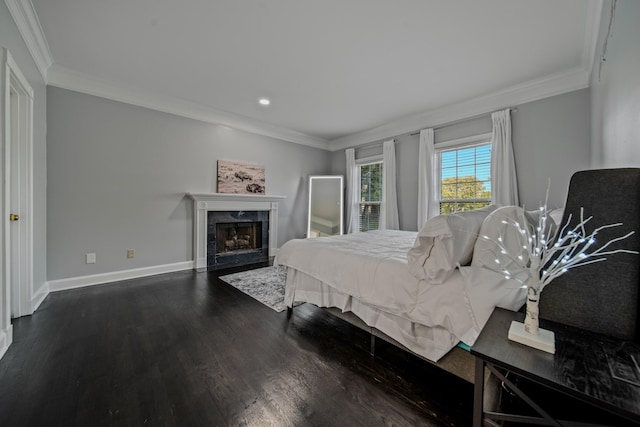 bedroom featuring ornamental molding, dark wood-type flooring, and a high end fireplace