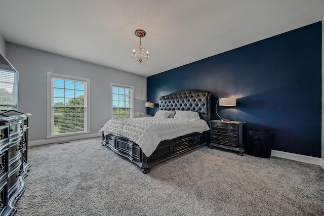 bedroom with carpet floors and an inviting chandelier