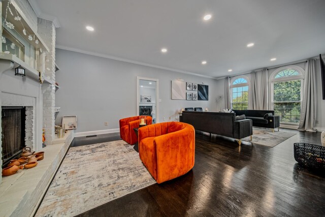 living room with crown molding, dark hardwood / wood-style floors, and a brick fireplace