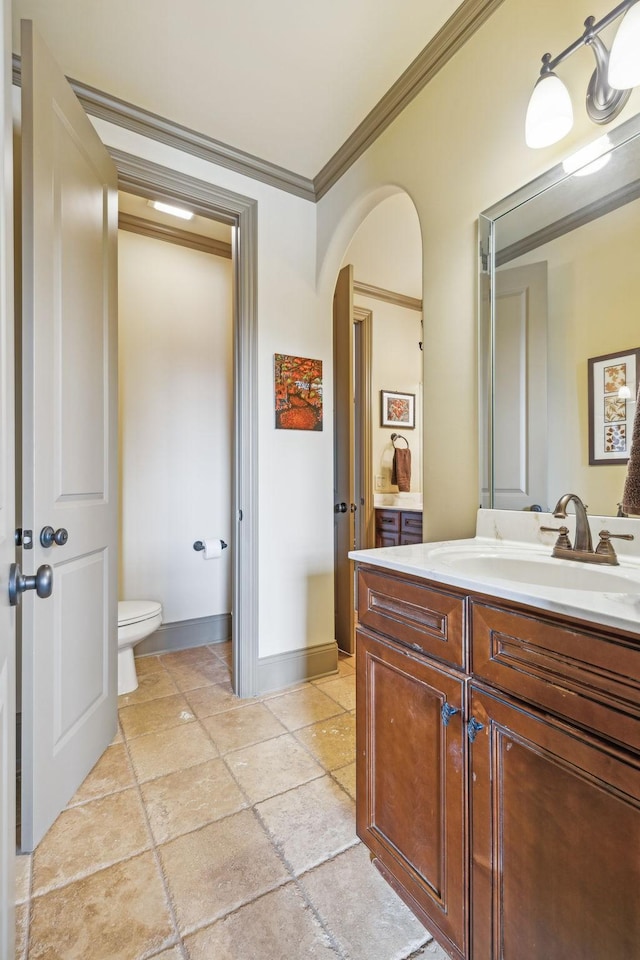 bathroom featuring vanity, toilet, and crown molding