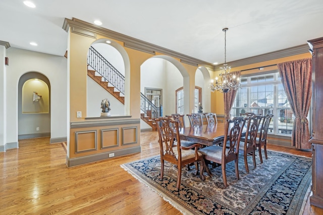 dining room with light hardwood / wood-style floors, ornamental molding, and a chandelier