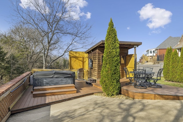 deck featuring a hot tub and a patio area