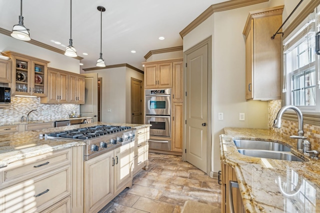 kitchen with backsplash, sink, light stone countertops, appliances with stainless steel finishes, and decorative light fixtures