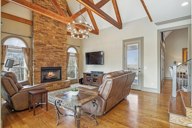 living room featuring an inviting chandelier, beamed ceiling, high vaulted ceiling, light hardwood / wood-style floors, and a fireplace