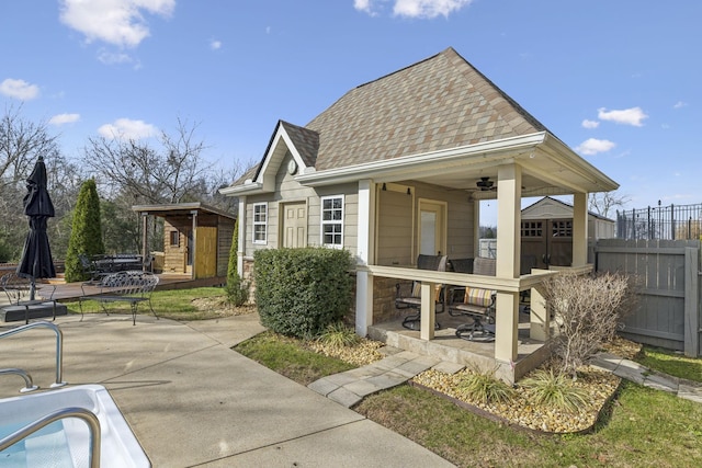 rear view of property featuring a patio area and a storage shed