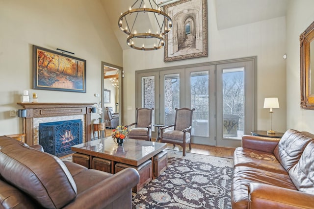 living room with hardwood / wood-style floors, high vaulted ceiling, french doors, and a notable chandelier