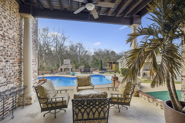 view of swimming pool featuring an outdoor living space with a fireplace, ceiling fan, and a patio