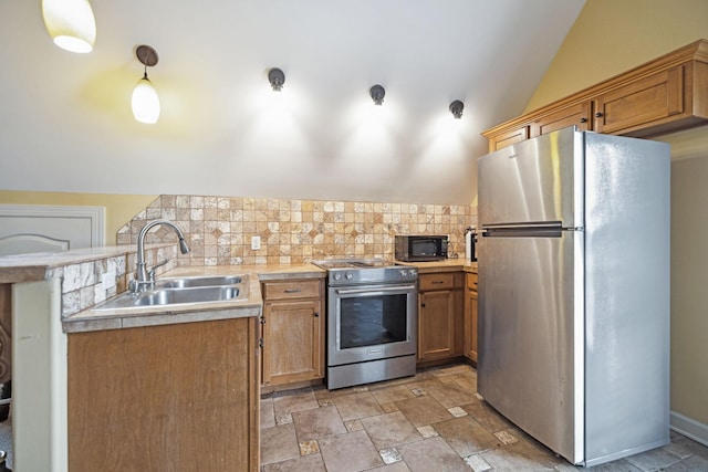 kitchen featuring sink, pendant lighting, vaulted ceiling, decorative backsplash, and appliances with stainless steel finishes