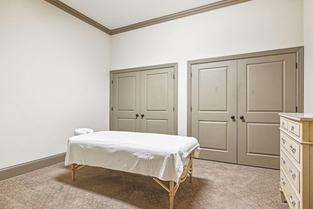 bedroom with multiple closets, light carpet, and crown molding