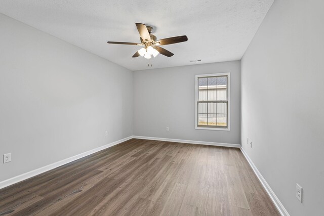 empty room featuring hardwood / wood-style flooring, ceiling fan, and a textured ceiling