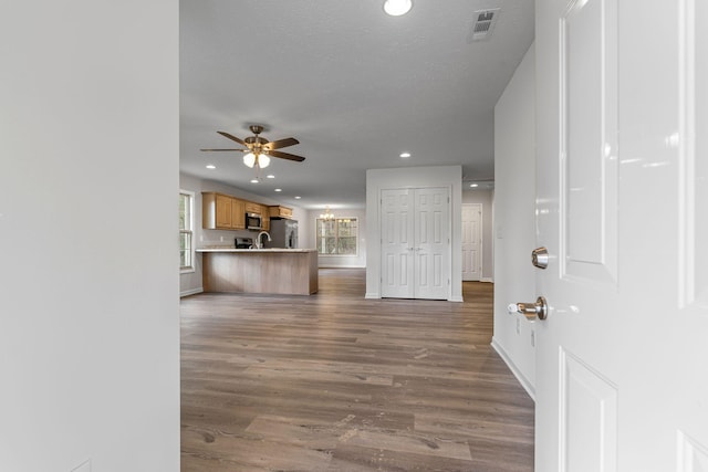 interior space with hardwood / wood-style floors, ceiling fan, sink, and a textured ceiling