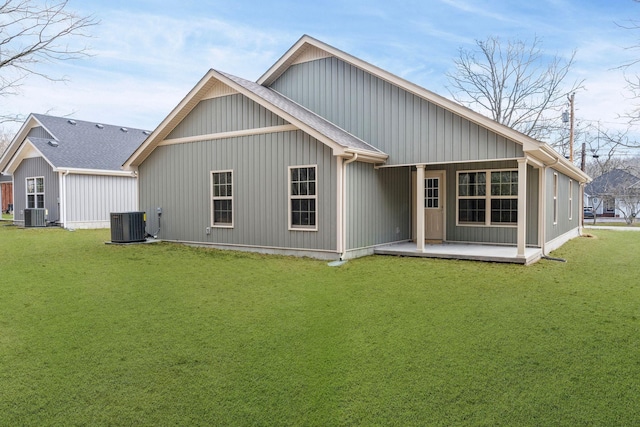 back of property with cooling unit and a yard