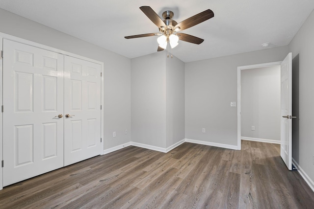 unfurnished bedroom with hardwood / wood-style flooring, ceiling fan, and a closet