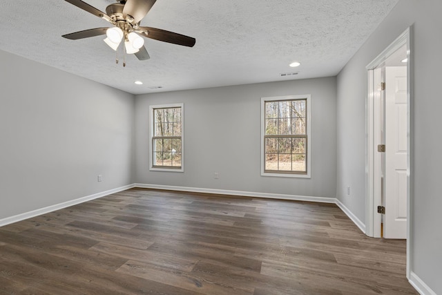 unfurnished room featuring a textured ceiling, dark hardwood / wood-style flooring, a wealth of natural light, and ceiling fan