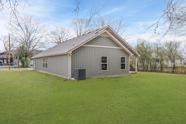 view of side of property with a lawn and central AC