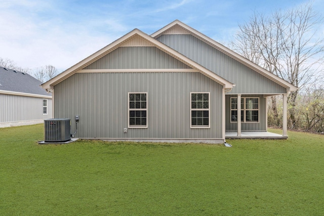 back of property featuring a yard and central AC